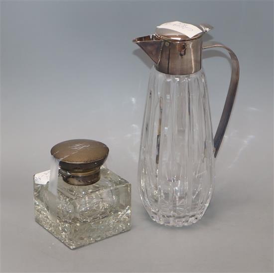 A silver-topped glass inkwell and a plated claret jug